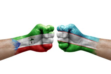 Two hands punch to each others on white background. Country flags painted fists, conflict crisis concept between equatorial guinea and uzbekistan