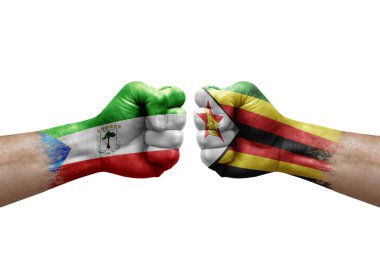 Two hands punch to each others on white background. Country flags painted fists, conflict crisis concept between equatorial guinea and zimbabwe