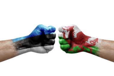 Two hands punch to each others on white background. Country flags painted fists, conflict crisis concept between estonia and wales