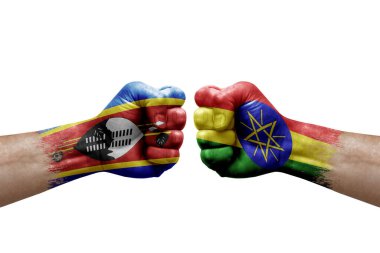 Two hands punch to each others on white background. Country flags painted fists, conflict crisis concept between eswatini and ethiopia
