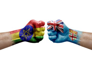 Two hands punch to each others on white background. Country flags painted fists, conflict crisis concept between ethiopia and fiji
