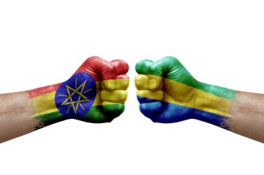 Two hands punch to each others on white background. Country flags painted fists, conflict crisis concept between ethiopia and gabon