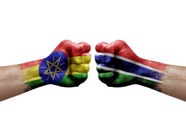 Two hands punch to each others on white background. Country flags painted fists, conflict crisis concept between ethiopia and gambia