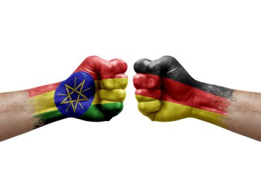 Two hands punch to each others on white background. Country flags painted fists, conflict crisis concept between ethiopia and germany