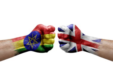 Two hands punch to each others on white background. Country flags painted fists, conflict crisis concept between ethiopia and britain