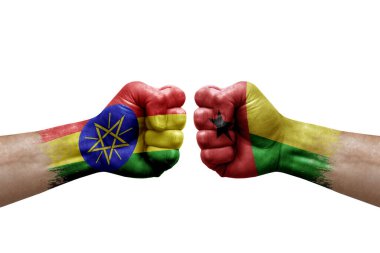 Two hands punch to each others on white background. Country flags painted fists, conflict crisis concept between ethiopia and guinea-bissau