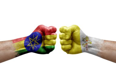 Two hands punch to each others on white background. Country flags painted fists, conflict crisis concept between ethiopia and holy see