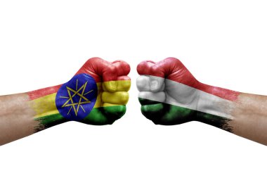Two hands punch to each others on white background. Country flags painted fists, conflict crisis concept between ethiopia and hungary