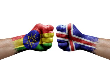Two hands punch to each others on white background. Country flags painted fists, conflict crisis concept between ethiopia and iceland