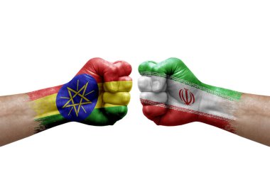 Two hands punch to each others on white background. Country flags painted fists, conflict crisis concept between ethiopia and iran