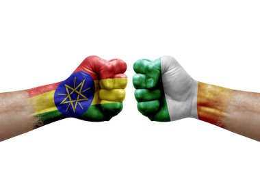 Two hands punch to each others on white background. Country flags painted fists, conflict crisis concept between ethiopia and ireland