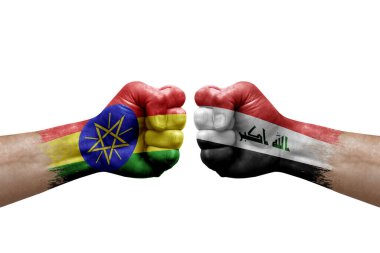 Two hands punch to each others on white background. Country flags painted fists, conflict crisis concept between ethiopia and iraq