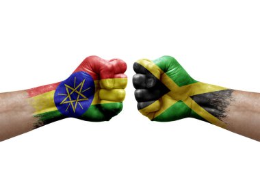 Two hands punch to each others on white background. Country flags painted fists, conflict crisis concept between ethiopia and jamaica