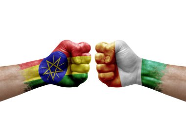 Two hands punch to each others on white background. Country flags painted fists, conflict crisis concept between ethiopia and ivory coast