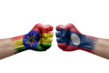 Two hands punch to each others on white background. Country flags painted fists, conflict crisis concept between ethiopia and laos