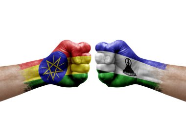Two hands punch to each others on white background. Country flags painted fists, conflict crisis concept between ethiopia and lesotho