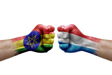 Two hands punch to each others on white background. Country flags painted fists, conflict crisis concept between ethiopia and luxembourg