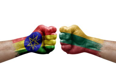 Two hands punch to each others on white background. Country flags painted fists, conflict crisis concept between ethiopia and lithuania