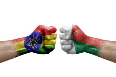 Two hands punch to each others on white background. Country flags painted fists, conflict crisis concept between ethiopia and madagascar