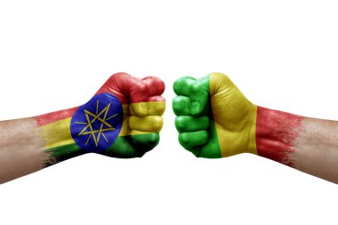 Two hands punch to each others on white background. Country flags painted fists, conflict crisis concept between ethiopia and mali