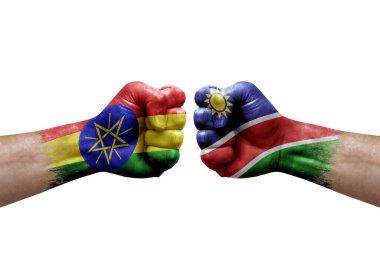 Two hands punch to each others on white background. Country flags painted fists, conflict crisis concept between ethiopia and namibia
