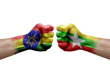 Two hands punch to each others on white background. Country flags painted fists, conflict crisis concept between ethiopia and myanmar