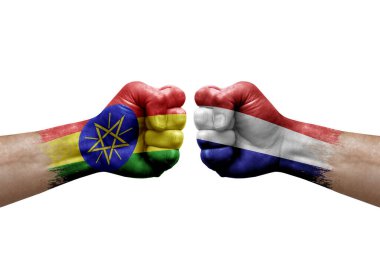 Two hands punch to each others on white background. Country flags painted fists, conflict crisis concept between ethiopia and netherlands