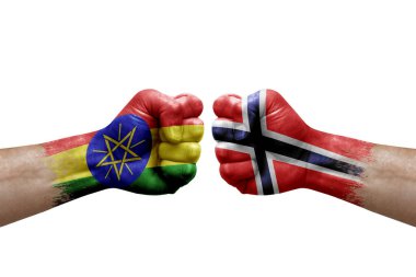 Two hands punch to each others on white background. Country flags painted fists, conflict crisis concept between ethiopia and norway