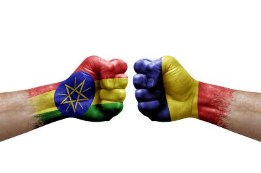 Two hands punch to each others on white background. Country flags painted fists, conflict crisis concept between ethiopia and romania
