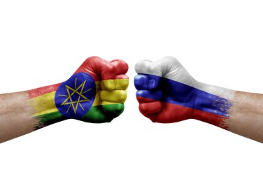Two hands punch to each others on white background. Country flags painted fists, conflict crisis concept between ethiopia and russia