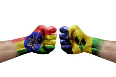 Two hands punch to each others on white background. Country flags painted fists, conflict crisis concept between ethiopia and saint vincent and the grenadines