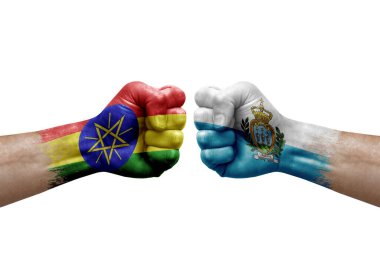 Two hands punch to each others on white background. Country flags painted fists, conflict crisis concept between ethiopia and san marino