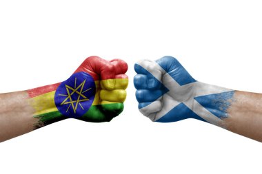 Two hands punch to each others on white background. Country flags painted fists, conflict crisis concept between ethiopia and scotland