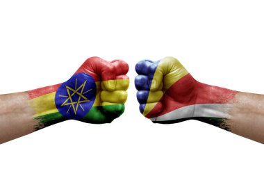 Two hands punch to each others on white background. Country flags painted fists, conflict crisis concept between ethiopia and seychelles