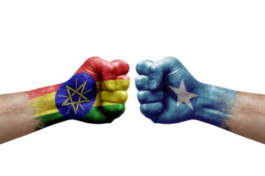 Two hands punch to each others on white background. Country flags painted fists, conflict crisis concept between ethiopia and somalia