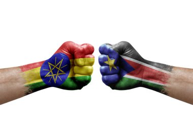 Two hands punch to each others on white background. Country flags painted fists, conflict crisis concept between ethiopia and south sudan