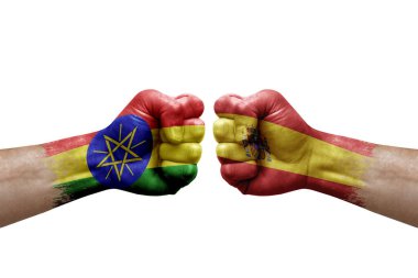 Two hands punch to each others on white background. Country flags painted fists, conflict crisis concept between ethiopia and spain