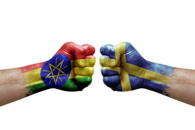 Two hands punch to each others on white background. Country flags painted fists, conflict crisis concept between ethiopia and sweden
