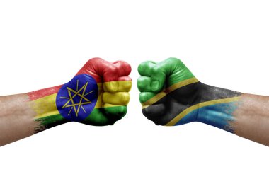 Two hands punch to each others on white background. Country flags painted fists, conflict crisis concept between ethiopia and tanzania