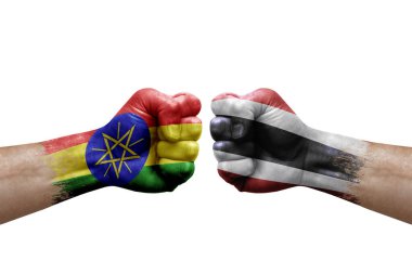 Two hands punch to each others on white background. Country flags painted fists, conflict crisis concept between ethiopia and thailand
