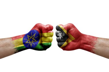Two hands punch to each others on white background. Country flags painted fists, conflict crisis concept between ethiopia and timor leste