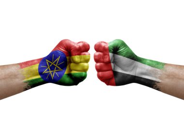 Two hands punch to each others on white background. Country flags painted fists, conflict crisis concept between ethiopia and united arab emirates
