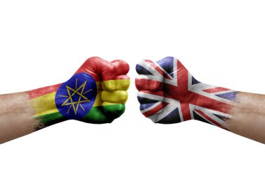Two hands punch to each others on white background. Country flags painted fists, conflict crisis concept between ethiopia and united kingdom