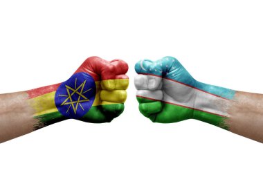Two hands punch to each others on white background. Country flags painted fists, conflict crisis concept between ethiopia and uzbekistan