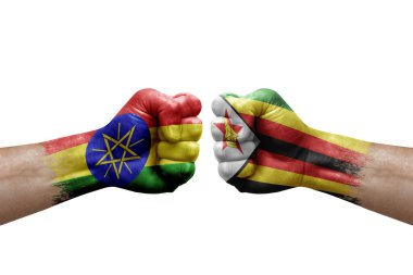 Two hands punch to each others on white background. Country flags painted fists, conflict crisis concept between ethiopia and zimbabwe