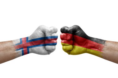 Two hands punch to each others on white background. Country flags painted fists, conflict crisis concept between faroe islands and germany