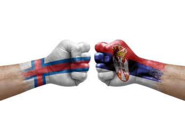 Two hands punch to each others on white background. Country flags painted fists, conflict crisis concept between faroe islands and serbia