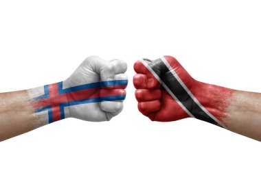 Two hands punch to each others on white background. Country flags painted fists, conflict crisis concept between faroe islands and tobago