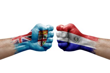 Two hands punch to each others on white background. Country flags painted fists, conflict crisis concept between fiji and paraguay