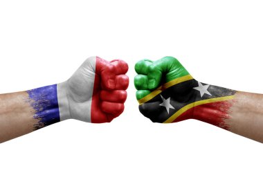 Two hands punch to each others on white background. Country flags painted fists, conflict crisis concept between france and saint kitts and nevis